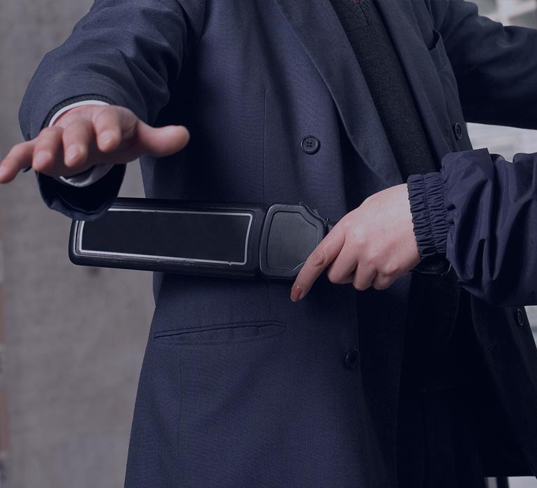 homme passant un détecteur à métaux sur un passager