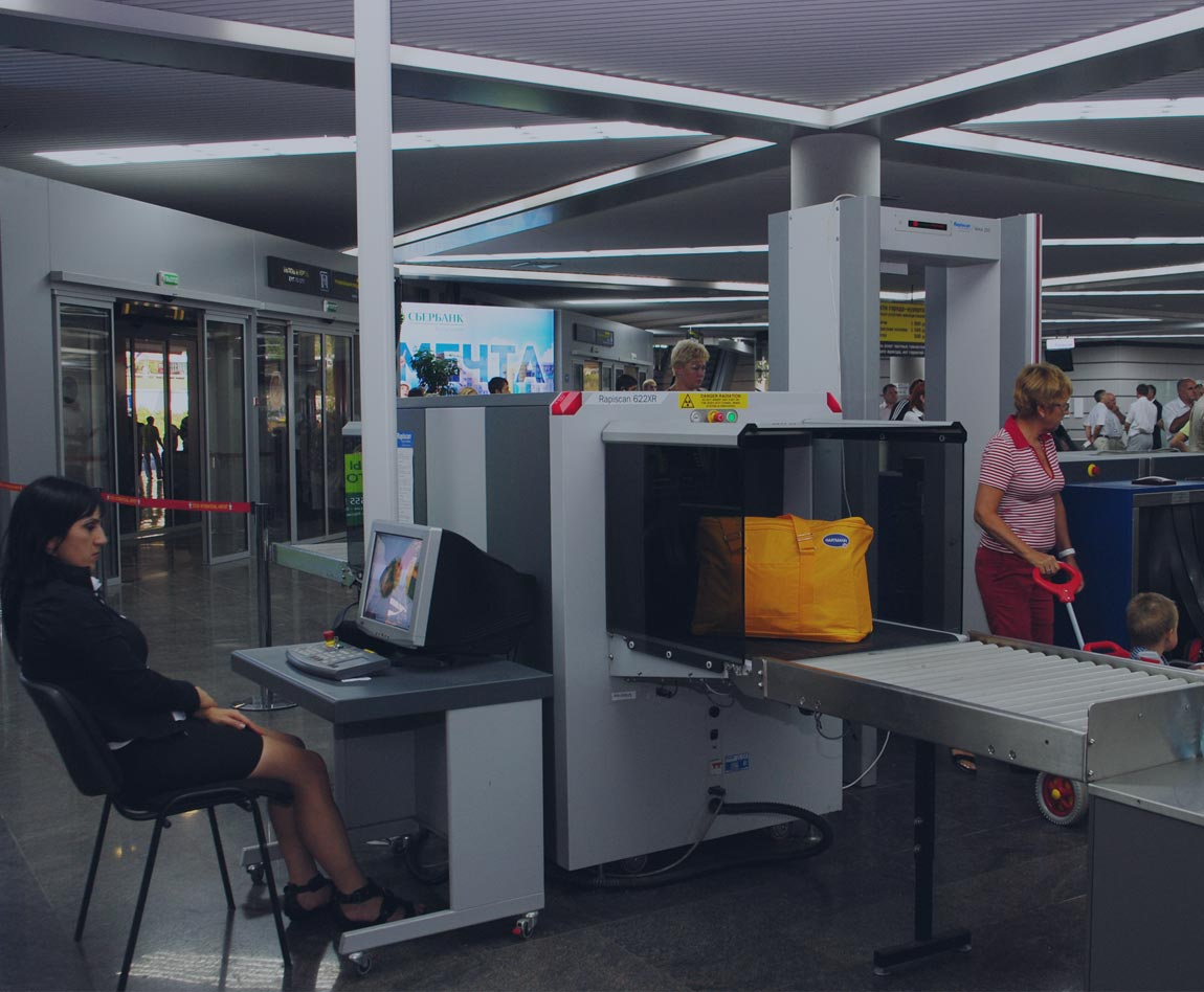 agent de sureté vérifiant les bagages à un portique d'aéroport