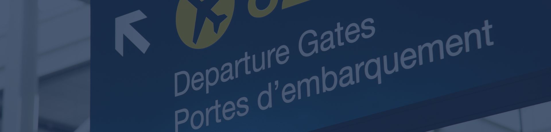 Panneau de signalisation d'aéroport indiquant "Departure Gates" et "Portes d'embarquement" avec une icône d'avion jaune.