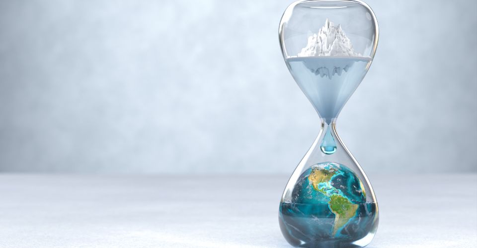 Sablier symbolisant le réchauffement climatique avec un iceberg fondu en haut et la Terre inondée en bas.