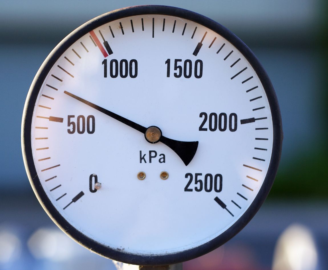 Manomètre industriel mesurant la pression en kPa, avec une aiguille indiquant environ 700.