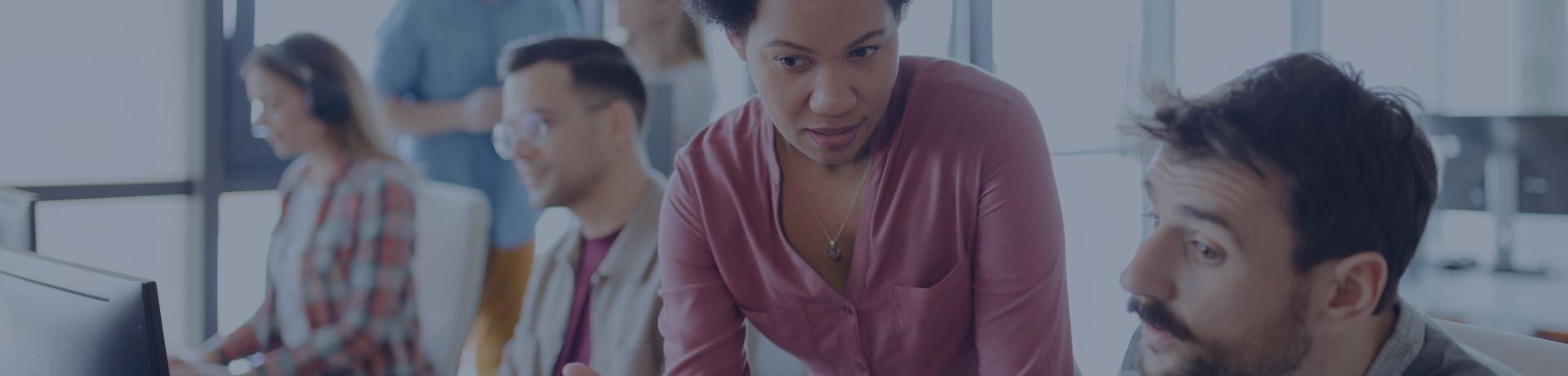 Une femme et un homme discute devant un ordinateur dans un bureau de travail