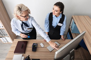 Femme réceptionniste enseignant à une stagiaire dans un hôtel