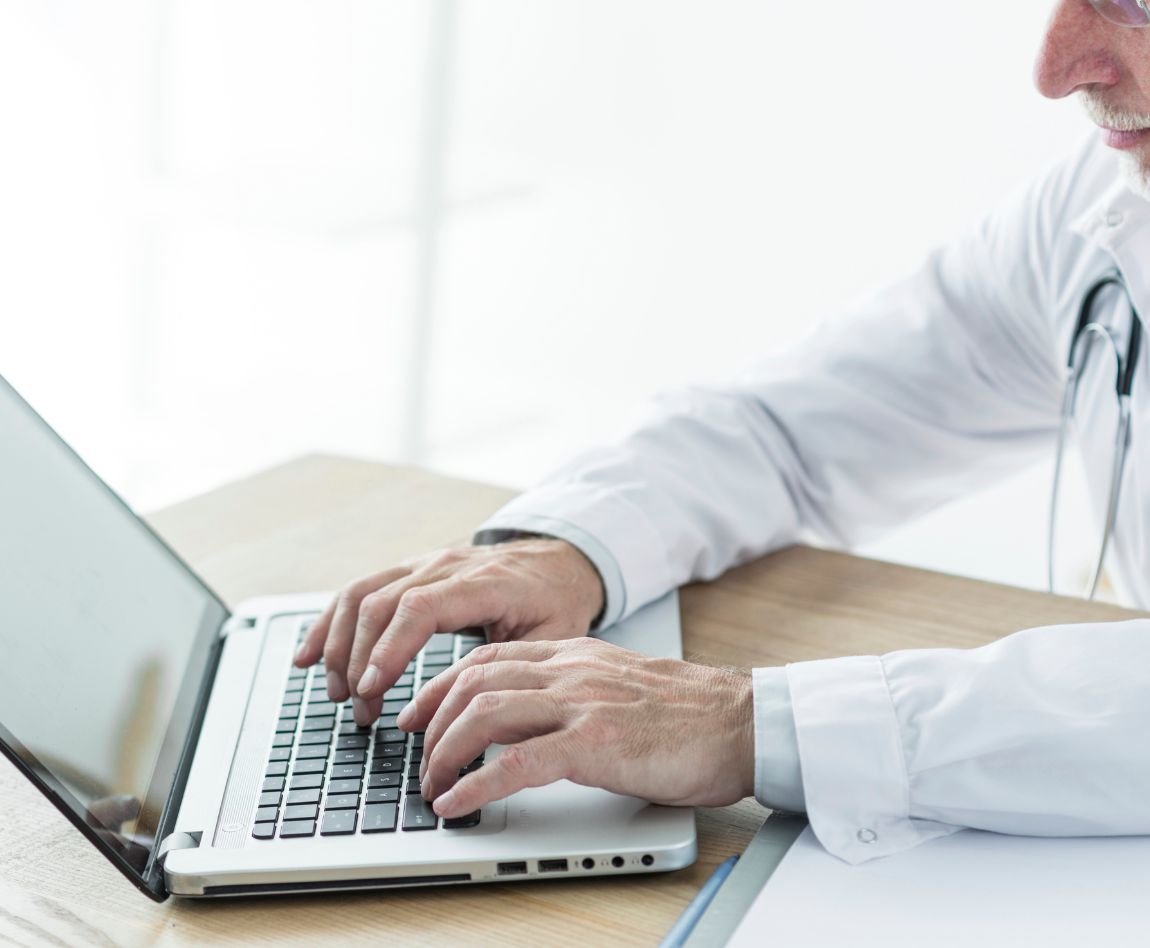 Médecin utilisant un ordinateur portable pour des données médicales sécurisées.