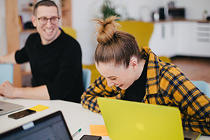 Une femme en train de rire avec son collègue