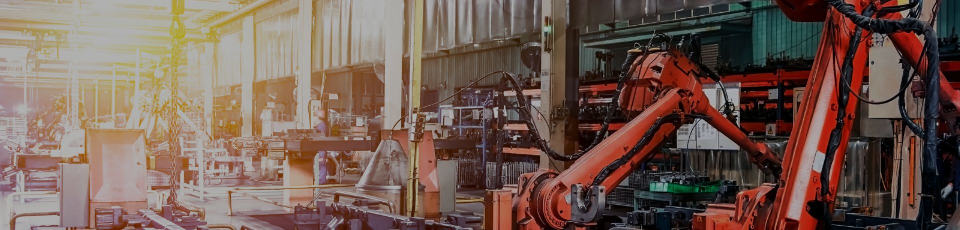 Chaîne de montage automatisée avec robots industriels rouges.