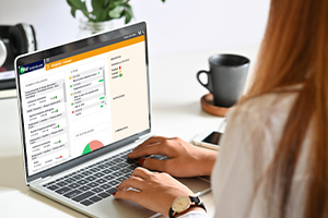 Une femme est assise à son bureau et utilise l'application Pilot Santé Sécurité sur son ordinateur