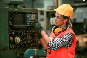Une femme avec un casque et des gants de protection