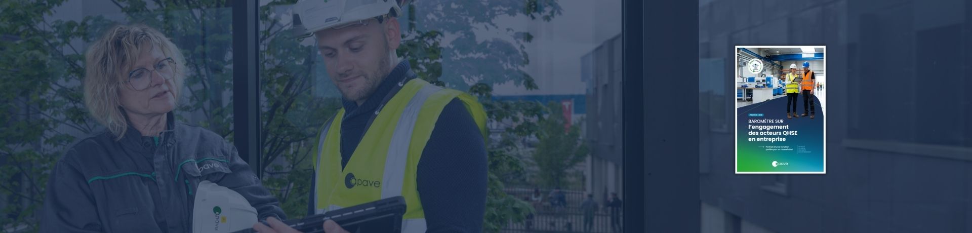 Deux agents Apave en tenue de travail et équipement de sécurité consultent une tablette.