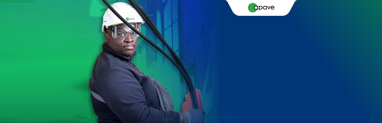 Un homme porte un casque blanc avec le logo Apave et tient des cables dans ses mains