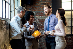 Groupe de collègues de travail joyeux en train de communiquer lors d'une pause café