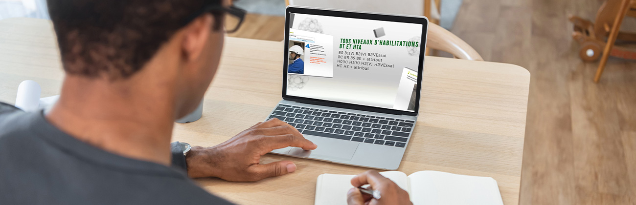 Un homme réalise une formation à distance grâce à son ordinateur