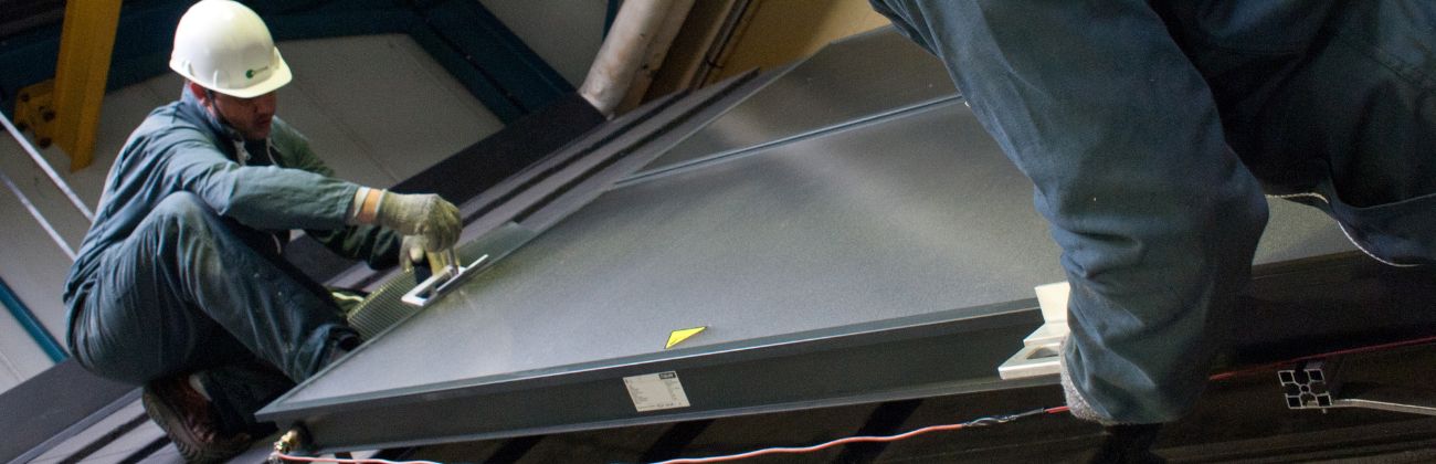 Deux collaborateurs Apave réalisent la maintenance d'un panneau photovoltaïque