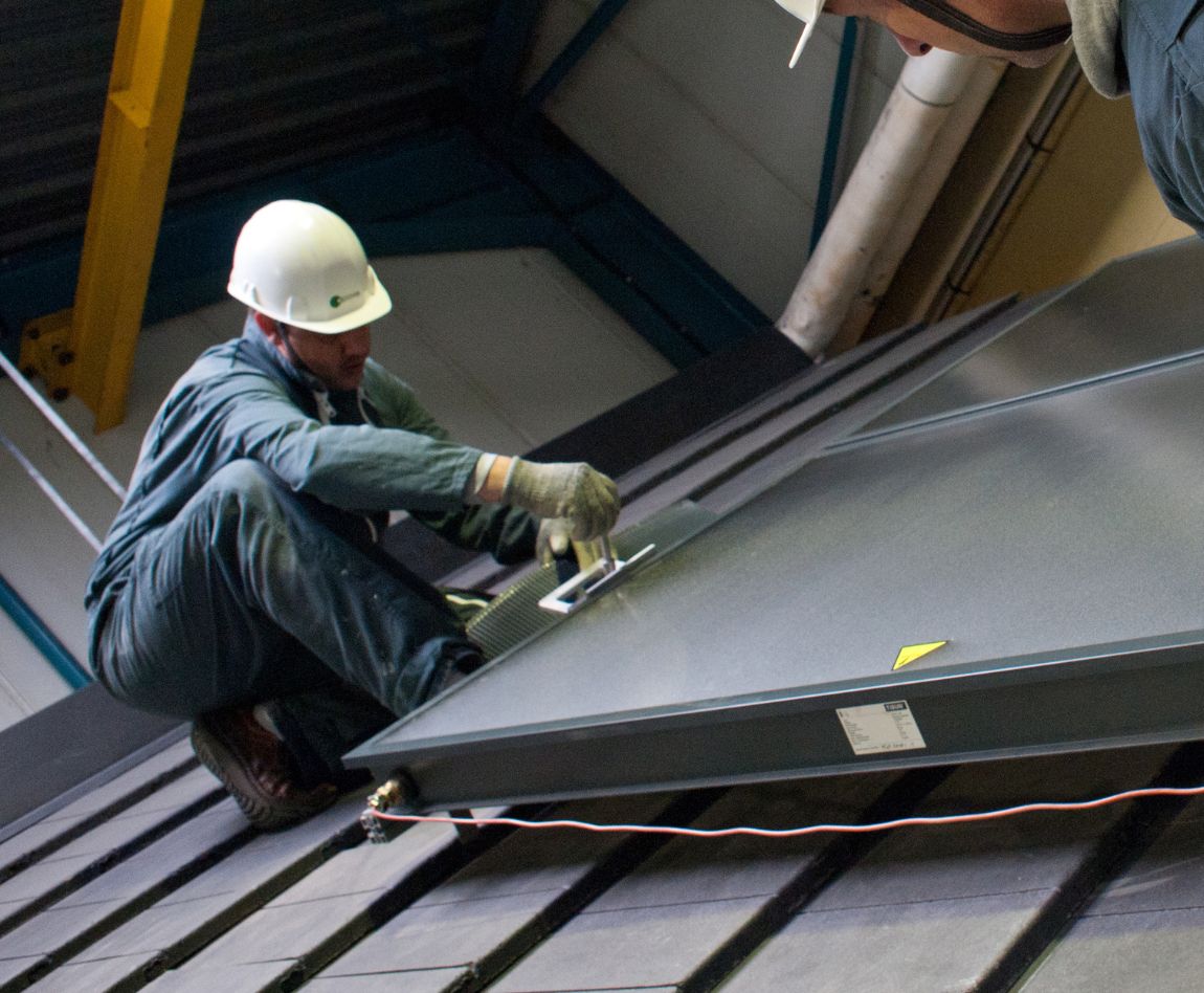 Deux collaborateurs Apave réalisent la maintenance d'un panneau photovoltaïque