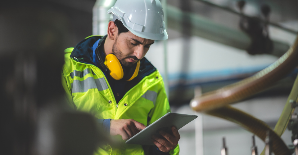 Un homme avec un ciret jaune et un casque regarde une tablette