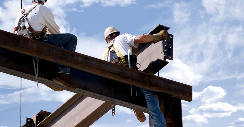 Deux ferronniers au sommet du squelette d'un bâtiment moderne