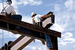 Deux ferronniers au sommet du squelette d'un bâtiment moderne
