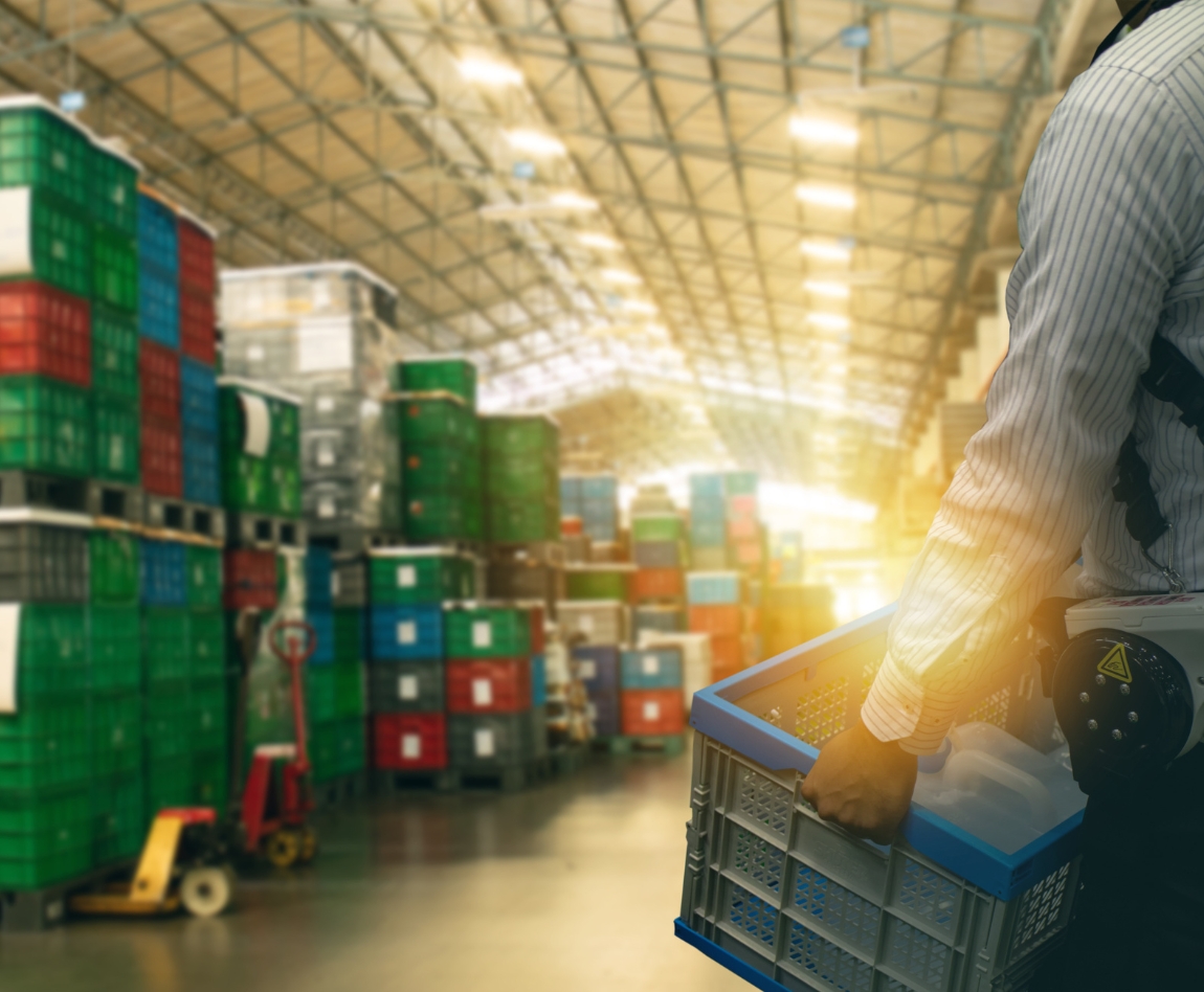 Entrepôt avec un travailleur portant un exosquelette à la taille