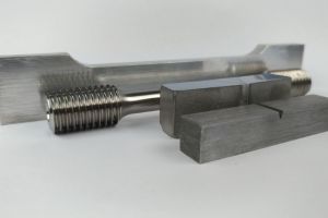 Diverses éprouvettes de laboratoire en métal, y compris une éprouvette de traction avec filetage et des éprouvettes pour essais de flexion.