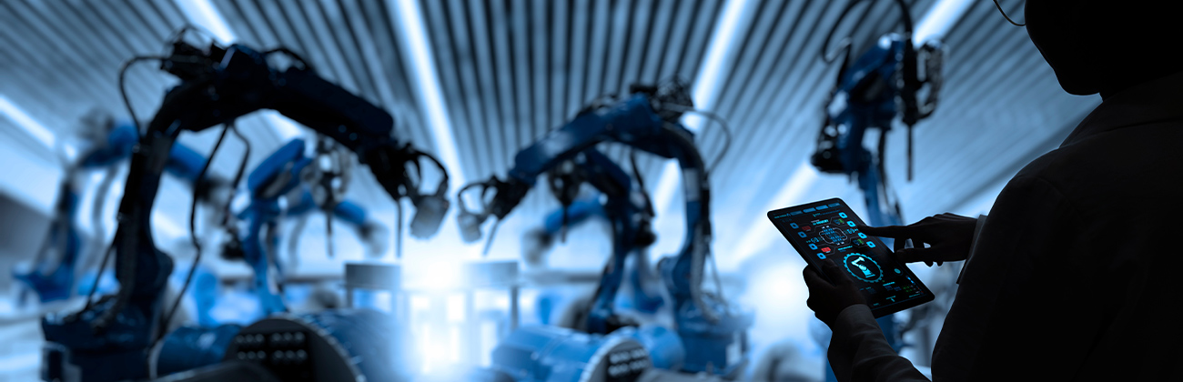 Greenbutterfly Une femme en train de vérifier sa tablette avec devant lui des bras articulés robotiques