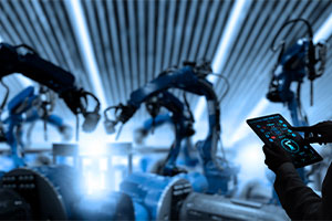 Une femme en train de vérifier sa tablette avec devant lui des bras articulés robotiques