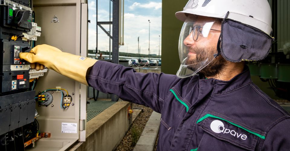 Électricien Apave contrôlant un tableau électrique pour assurer conformité et sécurité aux normes NFC 15-100.