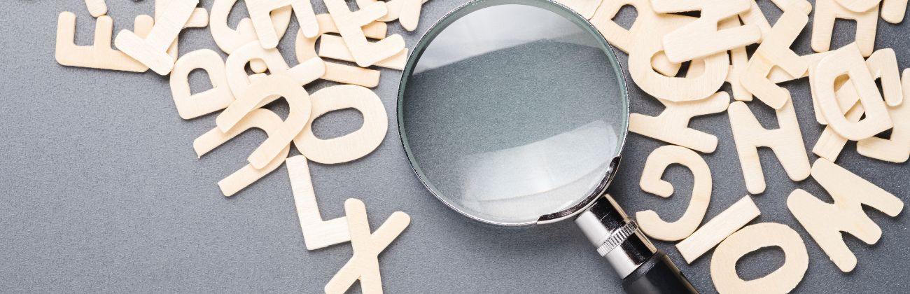 Loupe sur des lettres en bois.