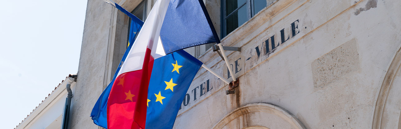 Un drapeau français et un drapeau européen sur le mur d'un hôtel de ville