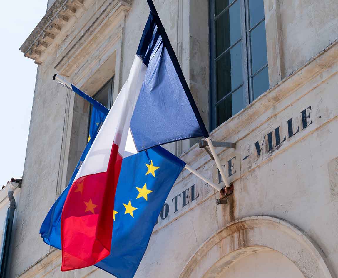 Un drapeau français et un drapeau européen sur le mur d'un hôtel de ville