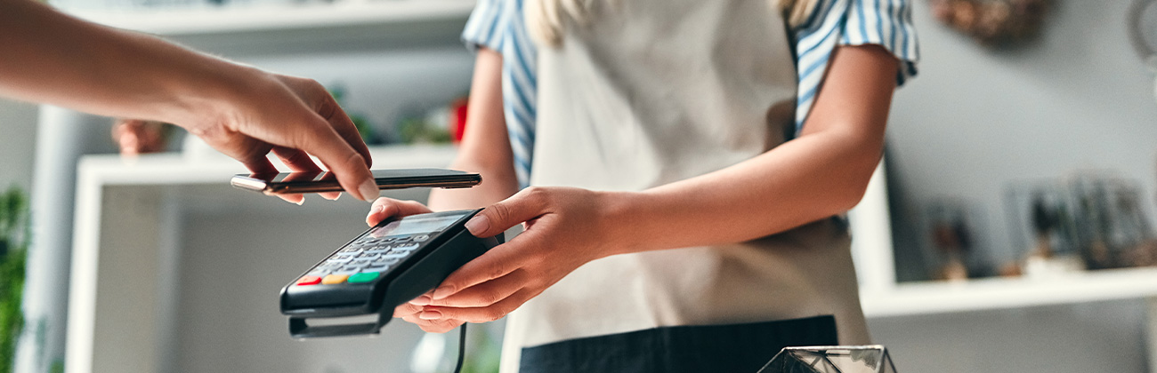 Une fleuriste tend un appareil bancaire à son client