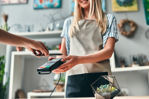 Une fleuriste tend un appareil bancaire à son client