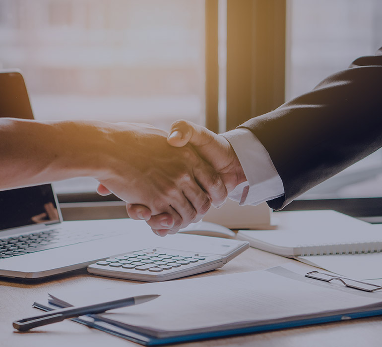 Deux personnes se serrent la main lors d'un rendez-vous d'affaires