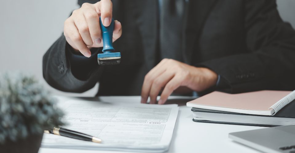 Agent d'affaires tamponnant un document administratif.