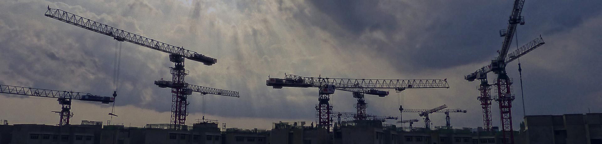 gru in un cantiere su uno sfondo di tramonto