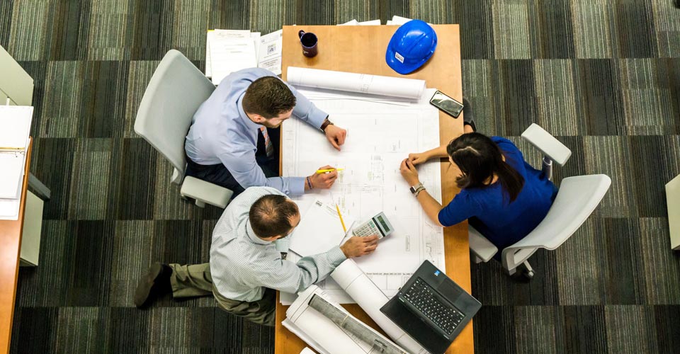 studio a tavolino con 3 persone su un sito di progetto