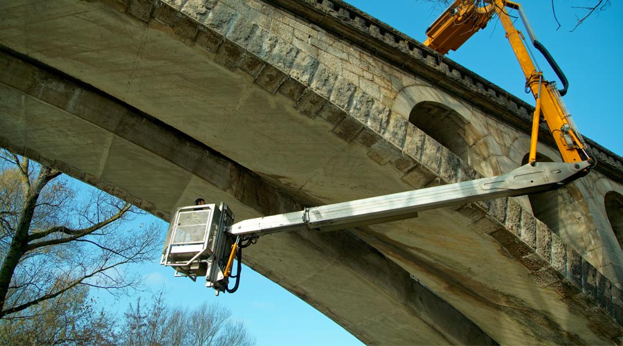 intervento di un lavoratore sotto un ponte tramite un braccio articolato pressurizzato