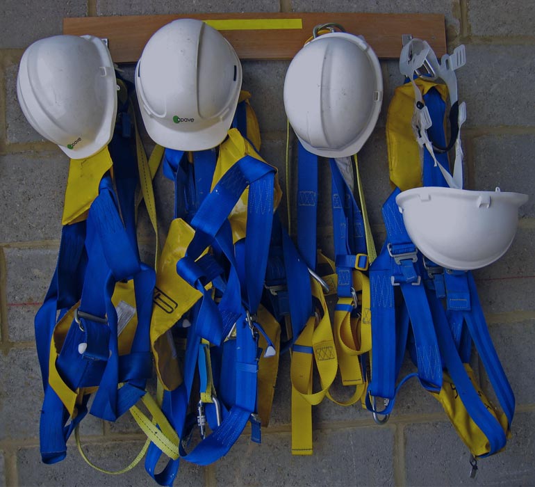 helmets and construction equipment hung in a locker room