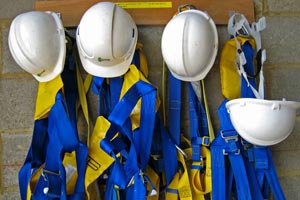 helmets and construction equipment hung in a locker room