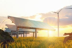 Solar panels and wind turbines in a rural landscape at sunset, symbolizing renewable energy and sustainability.