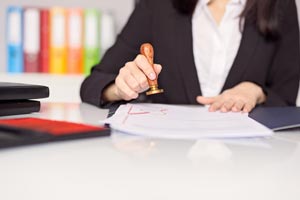 femme tamponnant une document d'accréditation