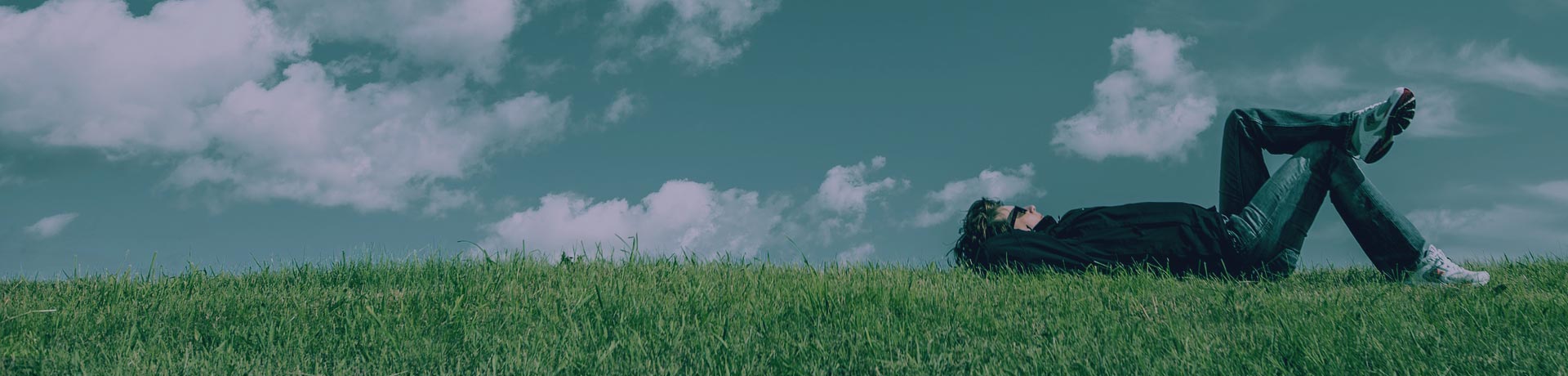 homme allongé dans l'herbe en train de réfléchir