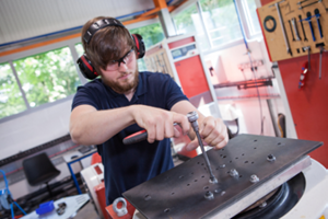 Un technicien réalise un montage sur une table de vibration