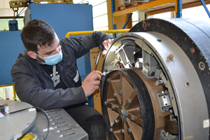 A man performs a maintenance operation on an equipment