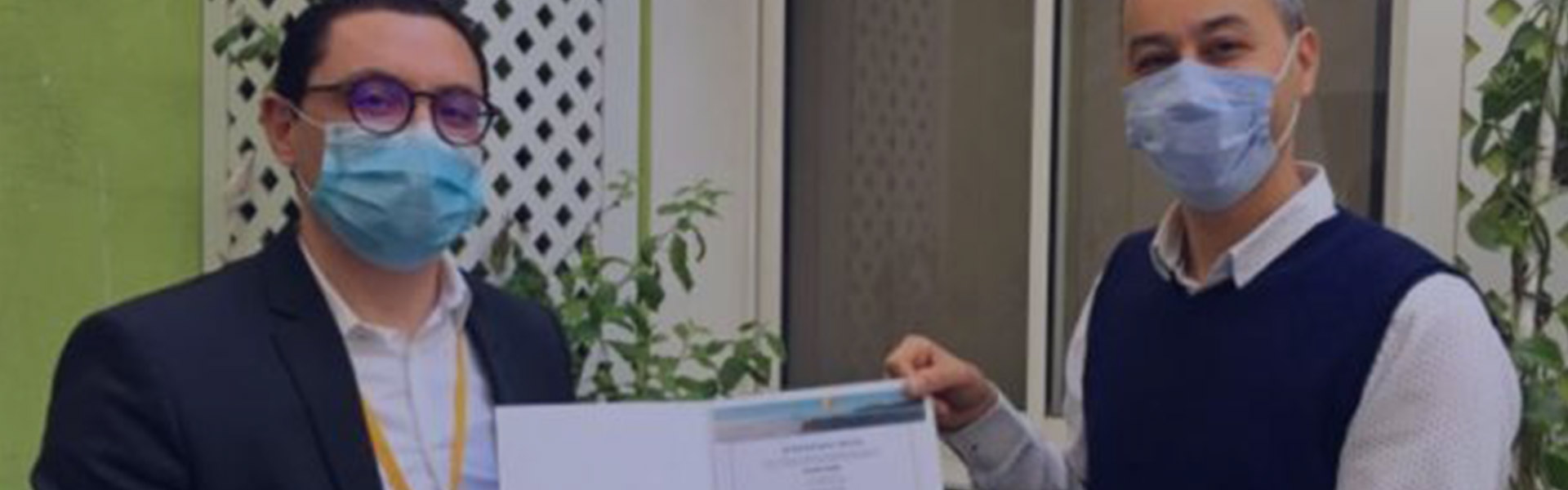 Deux hommes avec des masques tiennent un document dans leurs mains