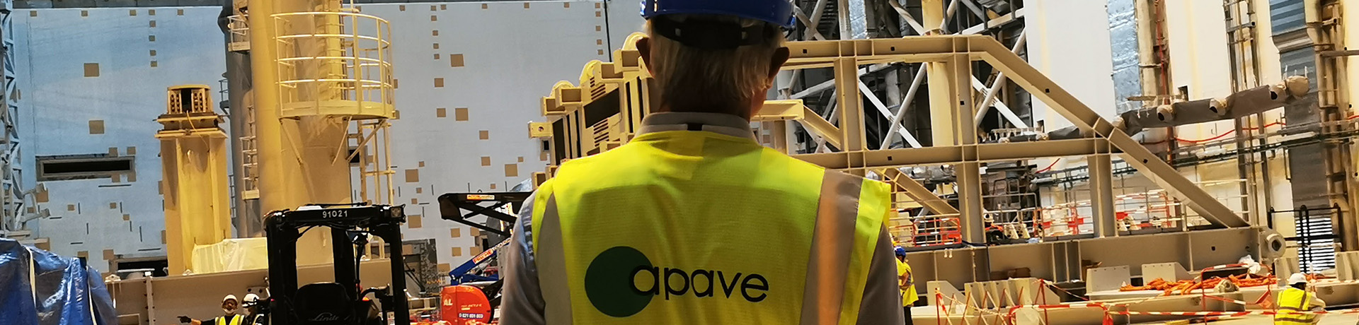 A man with a blue helmet and a yellow Apave waistcoat