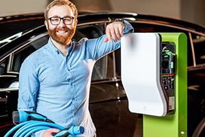 Un homme avec une borne de recharge pour voiture électrique