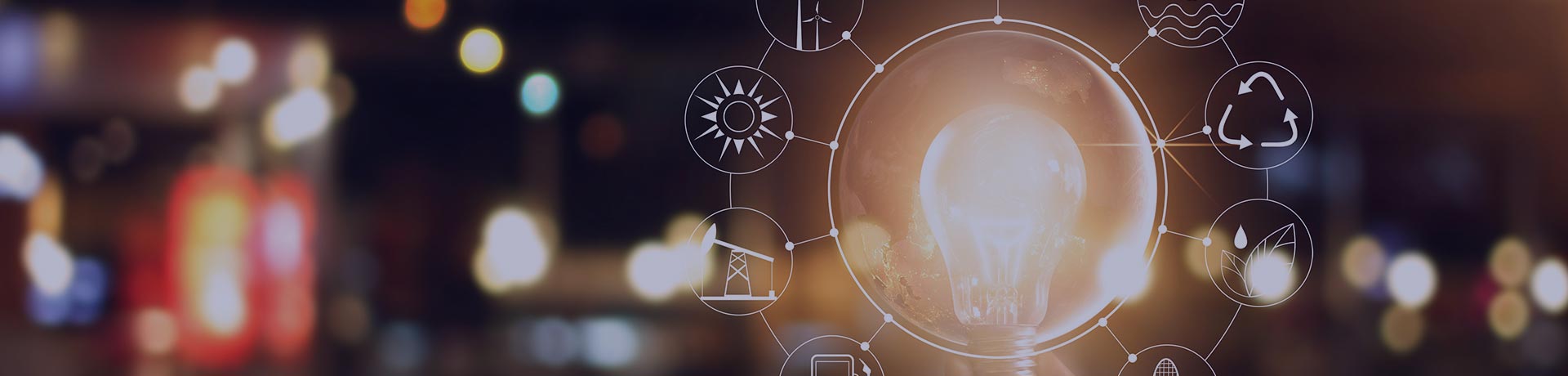 A hand holding a light bulb with various energy pictograms around it