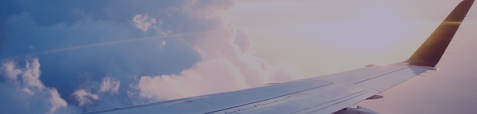 Une aile d'avion dans le ciel avec des nuages en arrière plan