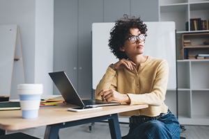 Une femme regarde par la fenêtre dans un open space de travail