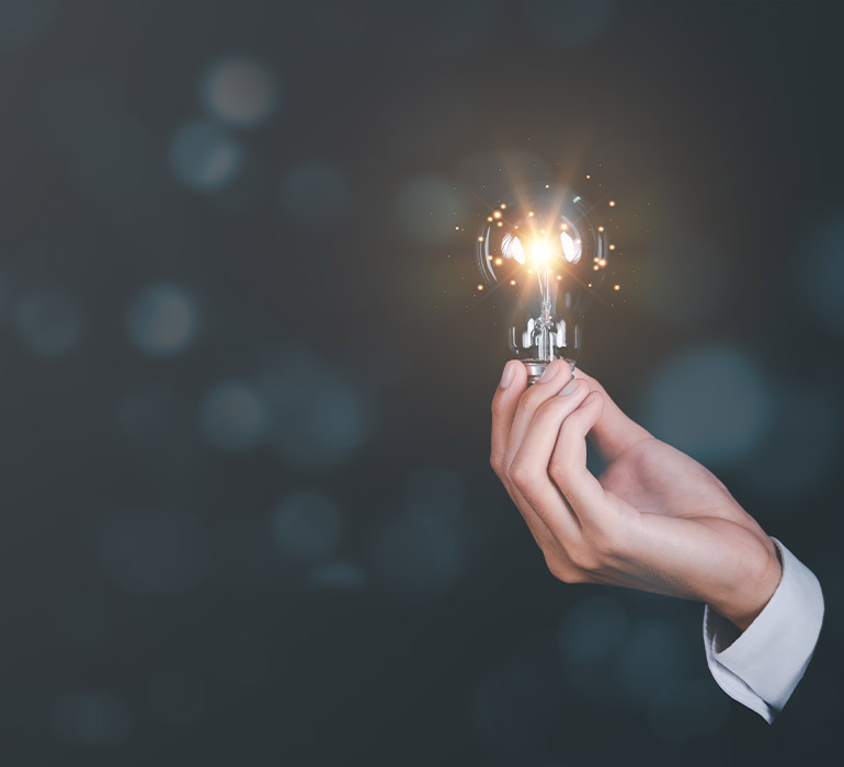 Main en costume tenant une ampoule